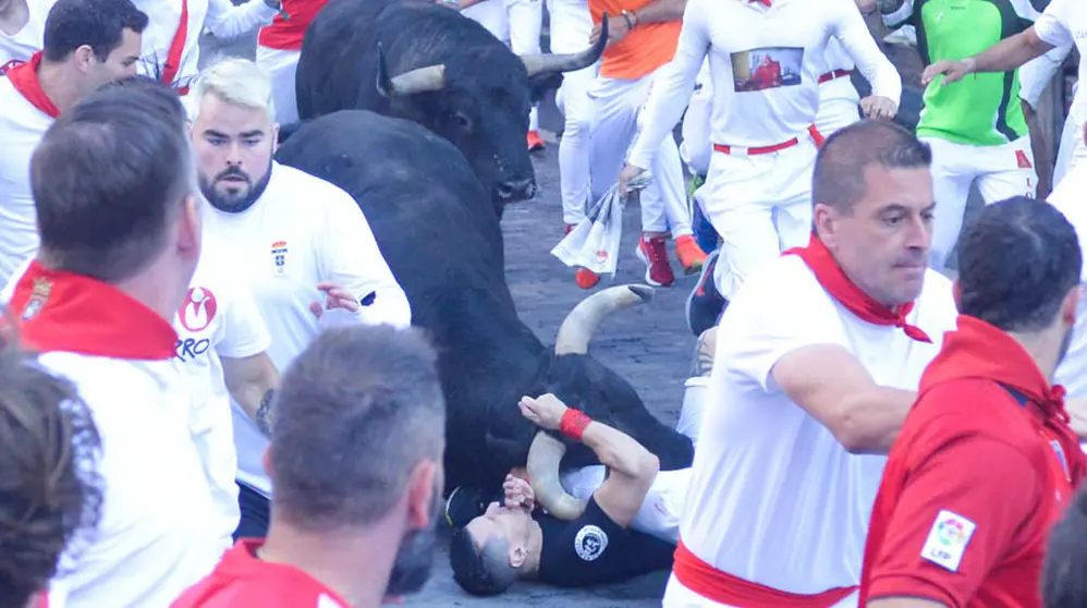 Cogida por asta de uno delos toros de Victoriano del Río en el tramo de Telefónica durante el quinto encierro de San Fermín 2019. IOSU PEZONAGA.
