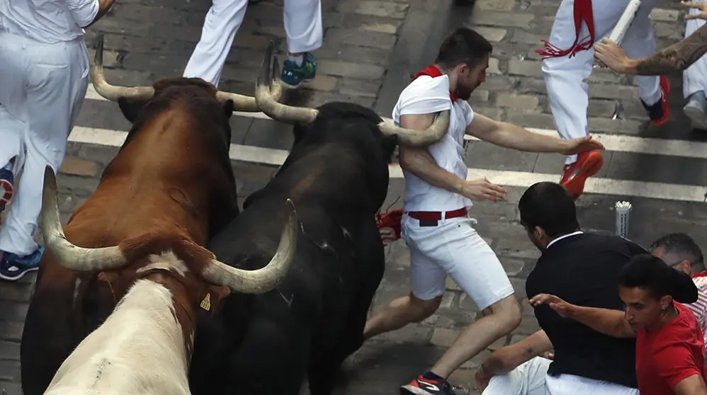 Los toros de la ganadería de La Palmosilla, de Tarifa (Cádiz), a su paso por la calle de Mercaderes, durante el séptimo encierro de los Sanfermines 2019.- EFE/Javier Lizón