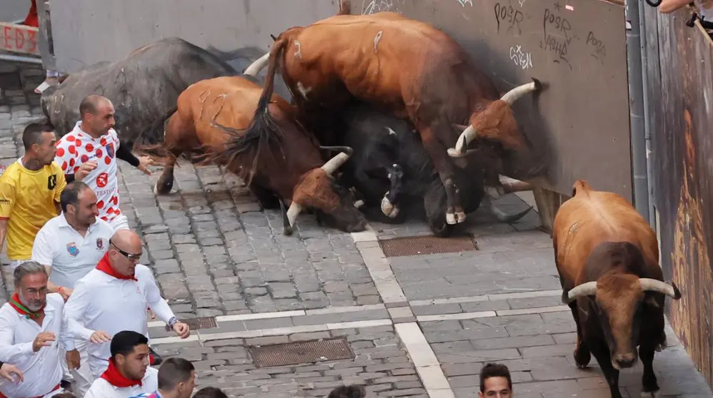 Los toros de la ganadería gaditana de Cebada Gago caen a su llegada a la curva de Mercaderes antes de enfilar la Estafeta durante el quinto encierro de los Sanfermines, este lunes en Pamplona. EFE Villar López