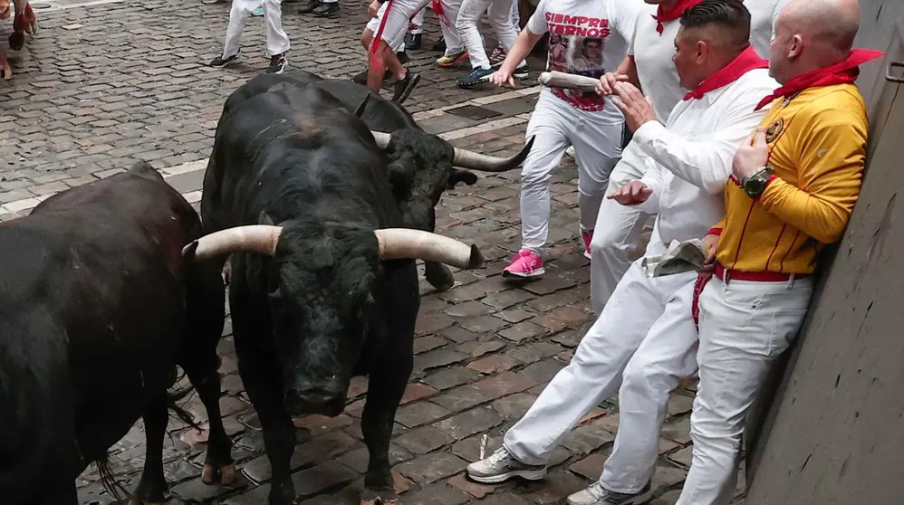 Mozos perseguidos por los toros de Victoriano del Río en el tercer encierro de los Sanfermines este martes, en Pamplona. EFE/Jesús Diges