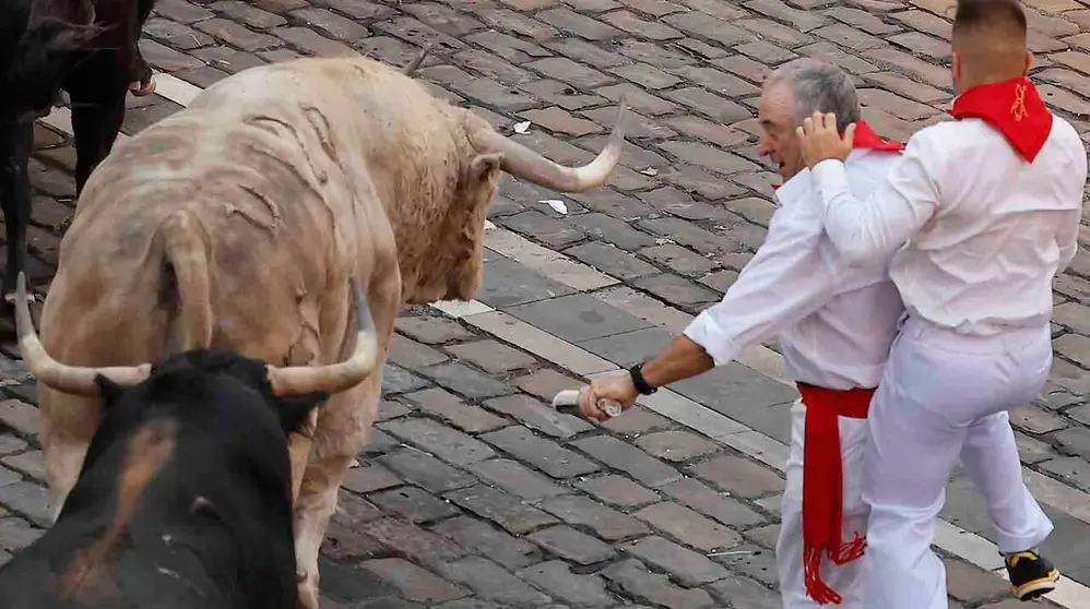 PAMPLONA, 07/07/2026.- Dos mozos se apartan de los toros de la ganader&iacute;a Fuente Ymbro en el tramo final que desemboca en el callej&oacute;n de la Plaza de Toros en el primer encierro de los Sanfermines 2026 este martes en Pamplona. EFE/Villar Lopez