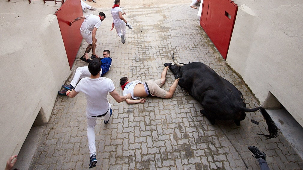 Inconsciente en el callejón: un mozo recibe los golpes de toda la manada en el primer encierro de San Fermín