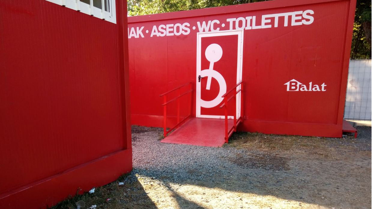 dificultad de acceso al baño de discapacitados por la gravilla de piedras en la entrada a la rampa