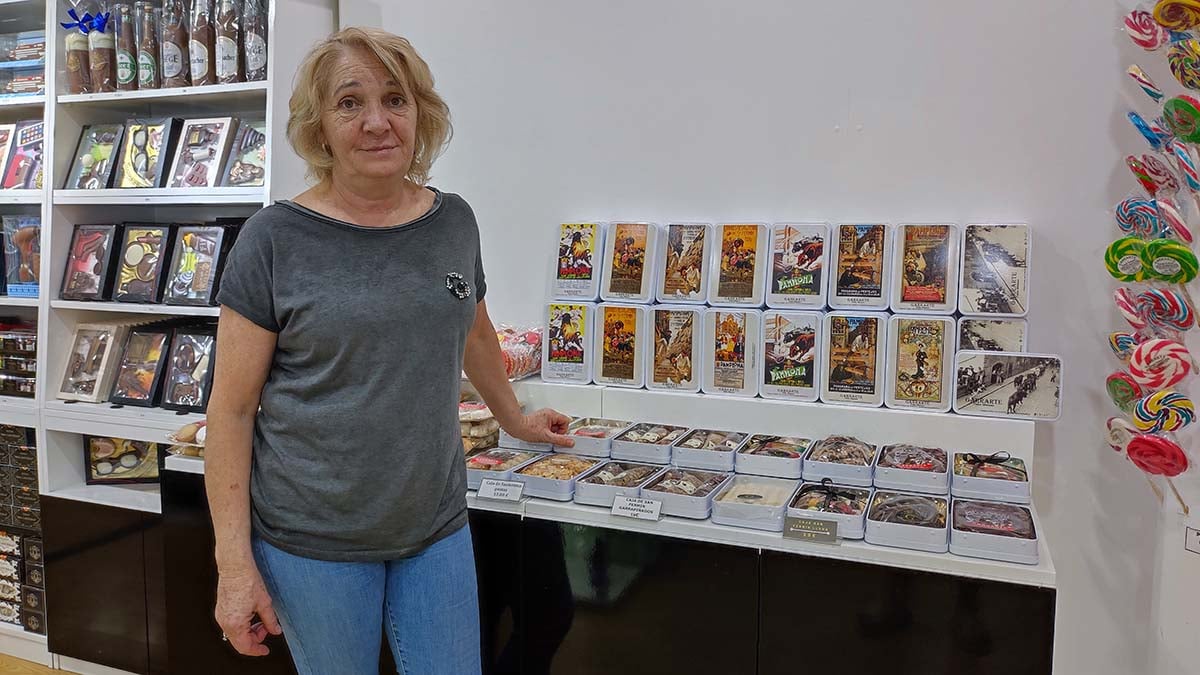 Yolanda López, dueña de ñla tienda de Garrarte en la Estafeta, junto con uno de sus productos más vendidos, las cajas de chocolate con los carteles. ANA BELÉN POZA