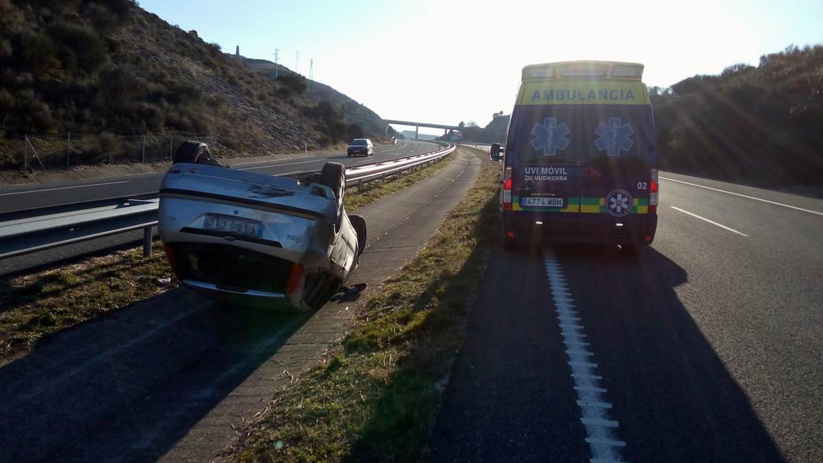 El vehículo ha quedado volcado sobre el techo en la mediana de la Autovía del Camino. BOMBEROS DE NAVARRA