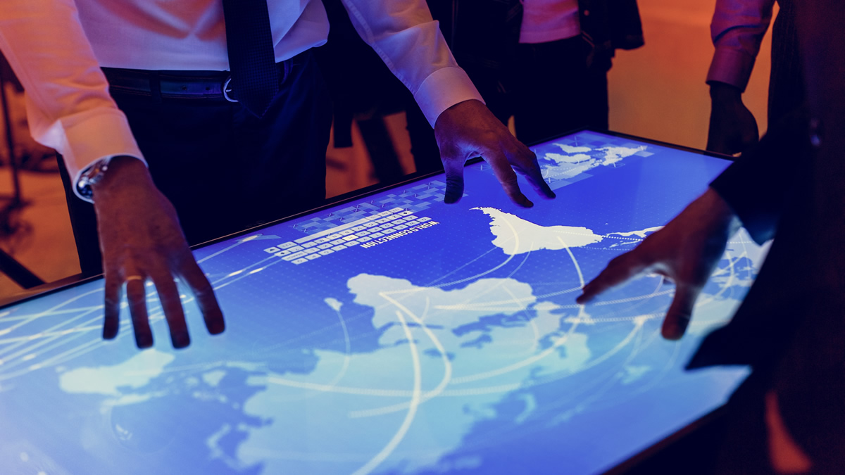 Un grupo de personas interactuando con una pantalla digital. CEDIDA