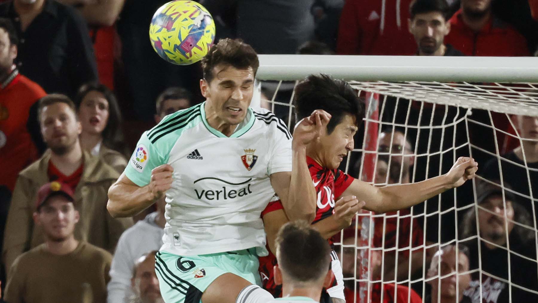 El centrocampista de Osasuna, Lucas Torró (i), despeja el balón ante el centrocampista coreano del Mallorca, Kang-in Lee, durante el encuentro correspondiente a la jornada 27 de primera división disputado hoy viernes en estadio Mallorca Son Moix. EFE/CATI CLADERA.