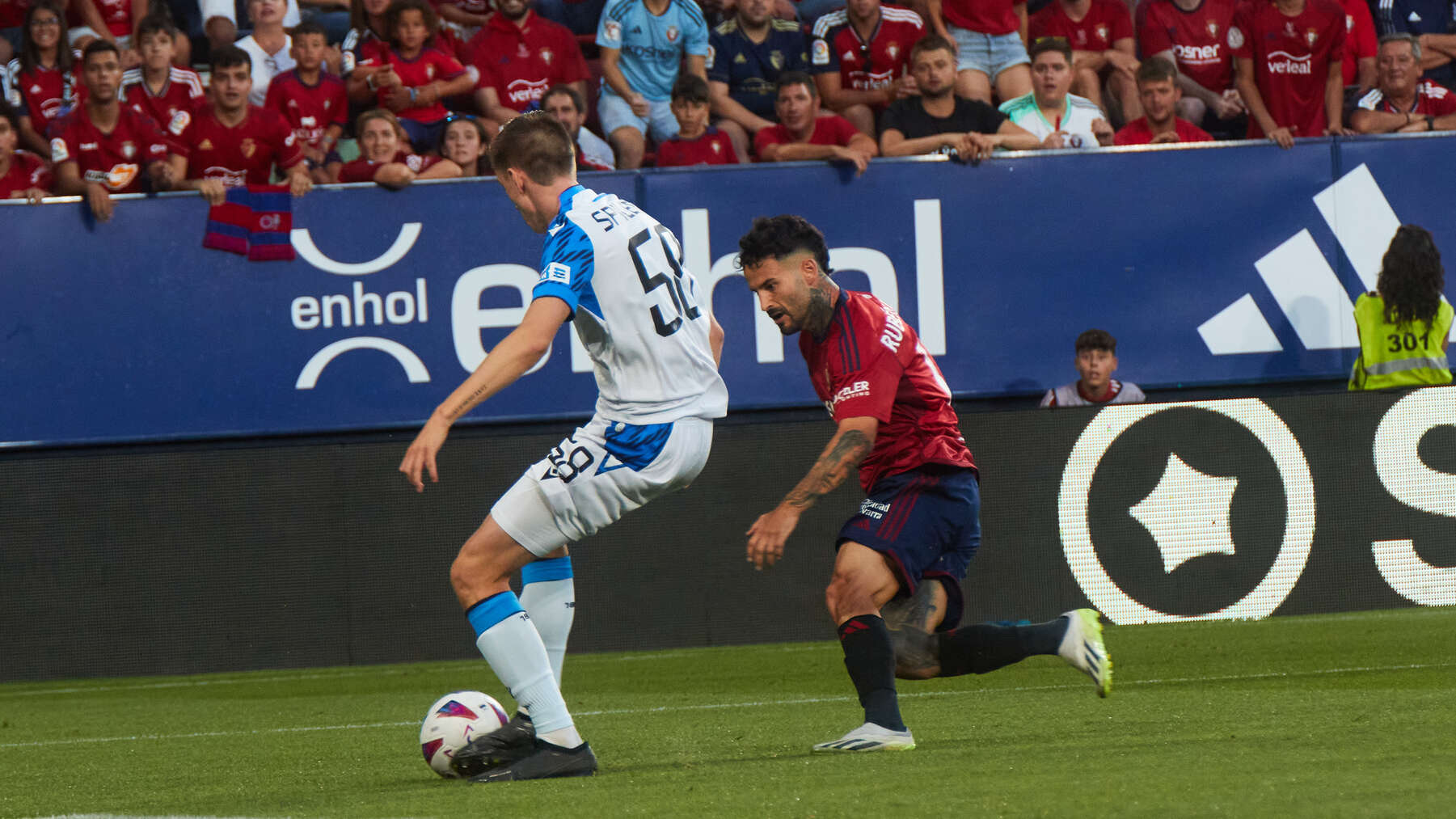 Jorne Spileers (58. Club Brugge ) y Rubén García (14. CA Osasuna) durante el partido de ida de la previa de la UEFA Europa Conference League entre CA Osasuna y Club Brugge disputado en el estadio de El Sadar en Pamplona. IÑIGO ALZUGARAY