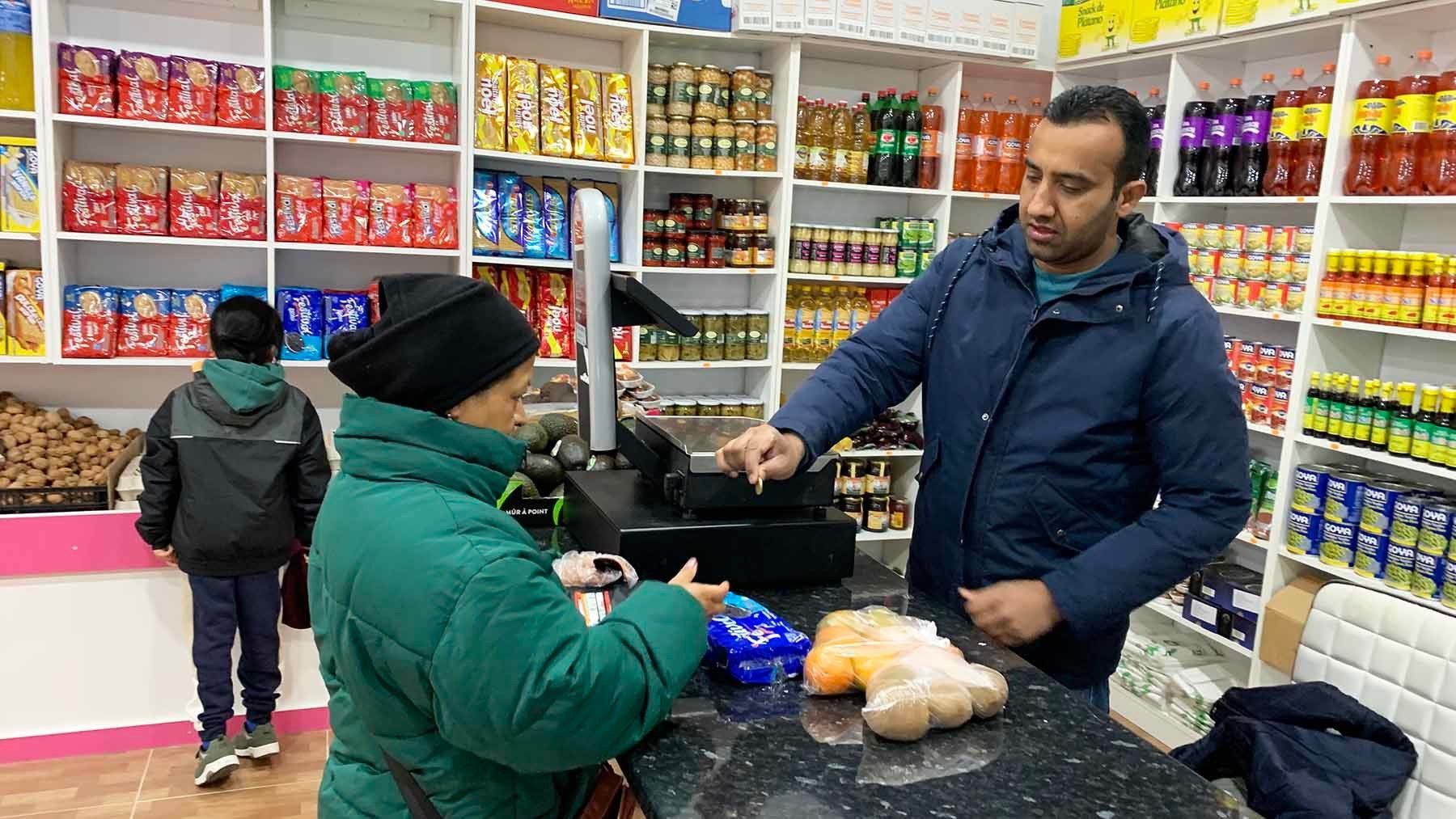 Imran Aziz devuelve el cambio a una clienta en su frutería de Pamplona. Navarra.com