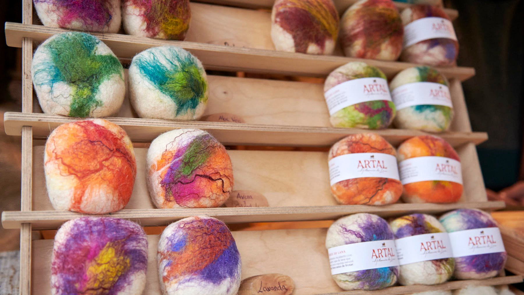 Alain Flores atiende en el puesto de Artal, un negocio de artesanía dedicado a la elaboración de productos hechos con lana. IRANZU LARRASOAÑA