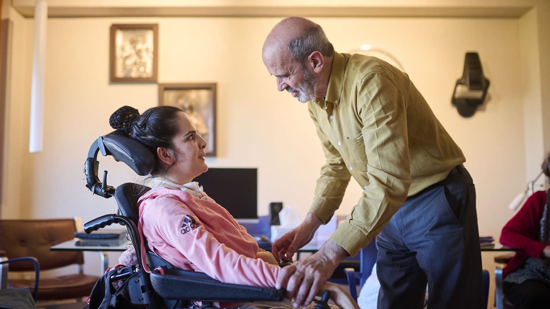 Marina Sacristán, en su silla de ruedas después de sufrir un íctus en 2027 cuando tenía 17 años, junto a sus padres Marta y José Antonio. PABLO LASAOSA