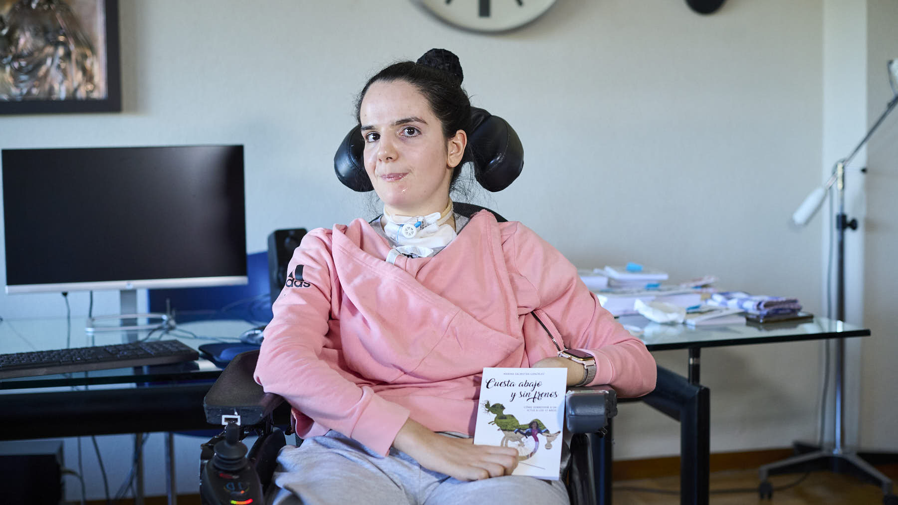 Marina Sacristán, en su silla de ruedas después de sufrir un íctus en 2027 cuando tenía 17 años, junto a sus padres Marta y José Antonio. PABLO LASAOSA