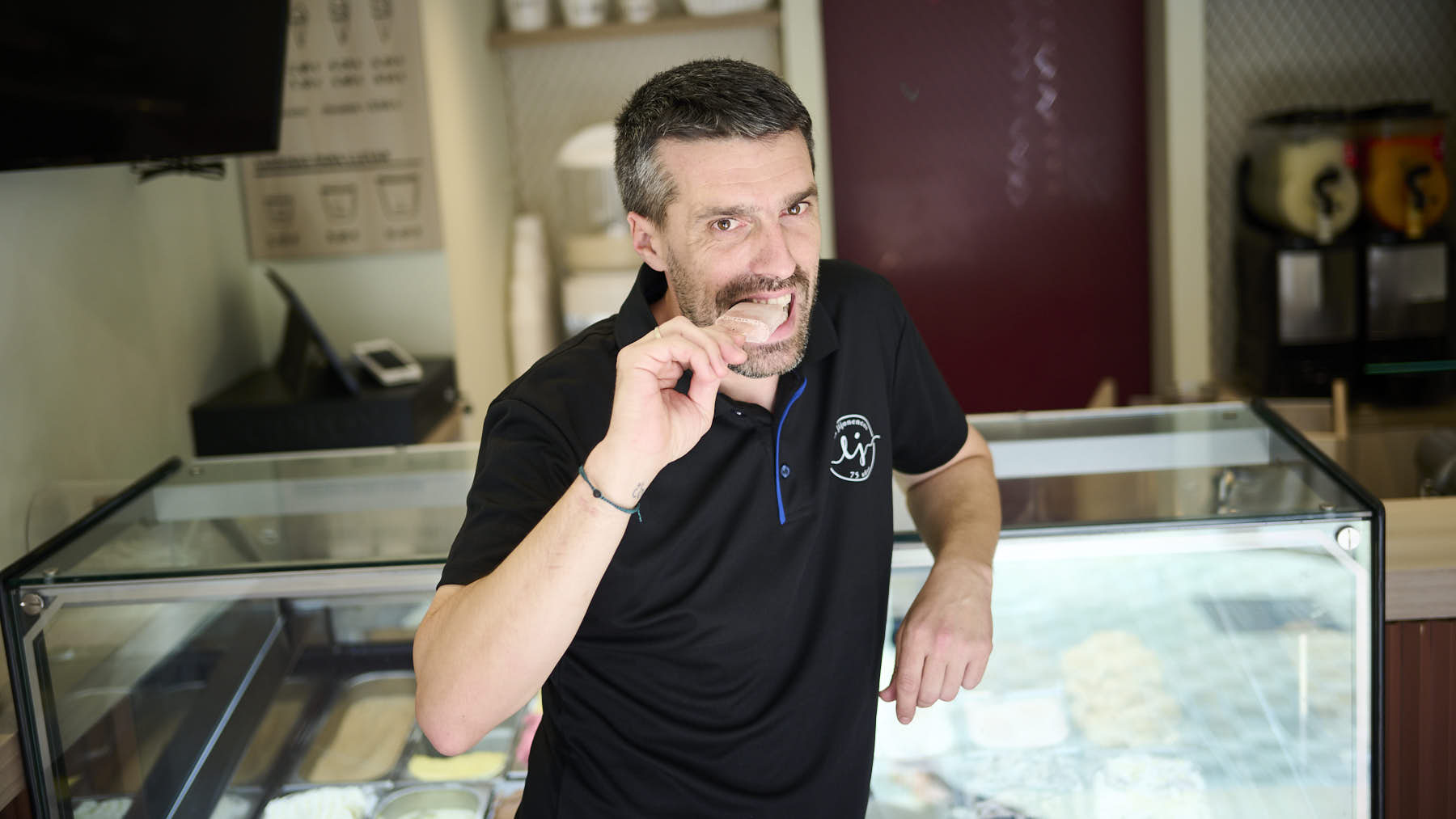 Mikel Falces con los polos de kalimotxo que ha sacado a la venta en la heladería Jijonencos para San Fermín 2024. PABLO LASAOSA