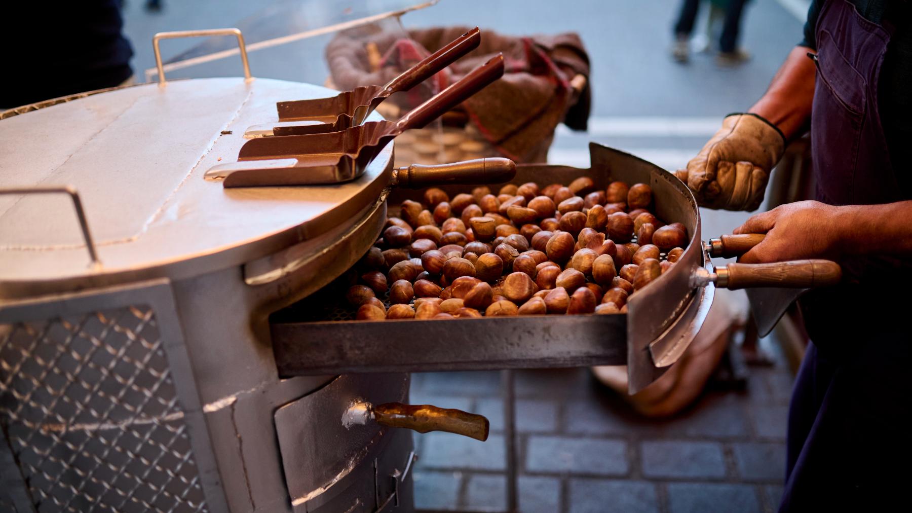 Míkel Álvarez sostiene sus famosas castañas asadas en su puesto de la plaza de San Nicolás. PABLO LASAOSA.