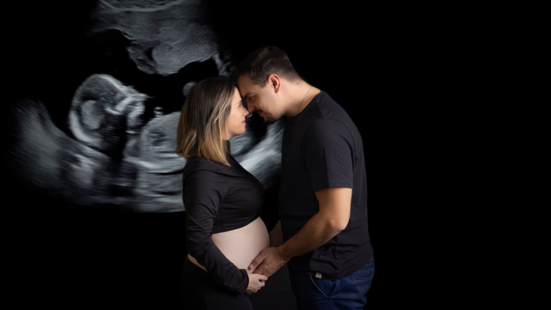 Imagen de una fotografía de una pareja que espera un bebé sobre el fondo de la ecografía. GALERNA FOTOGRAFÍA / ECOILUSIÓN