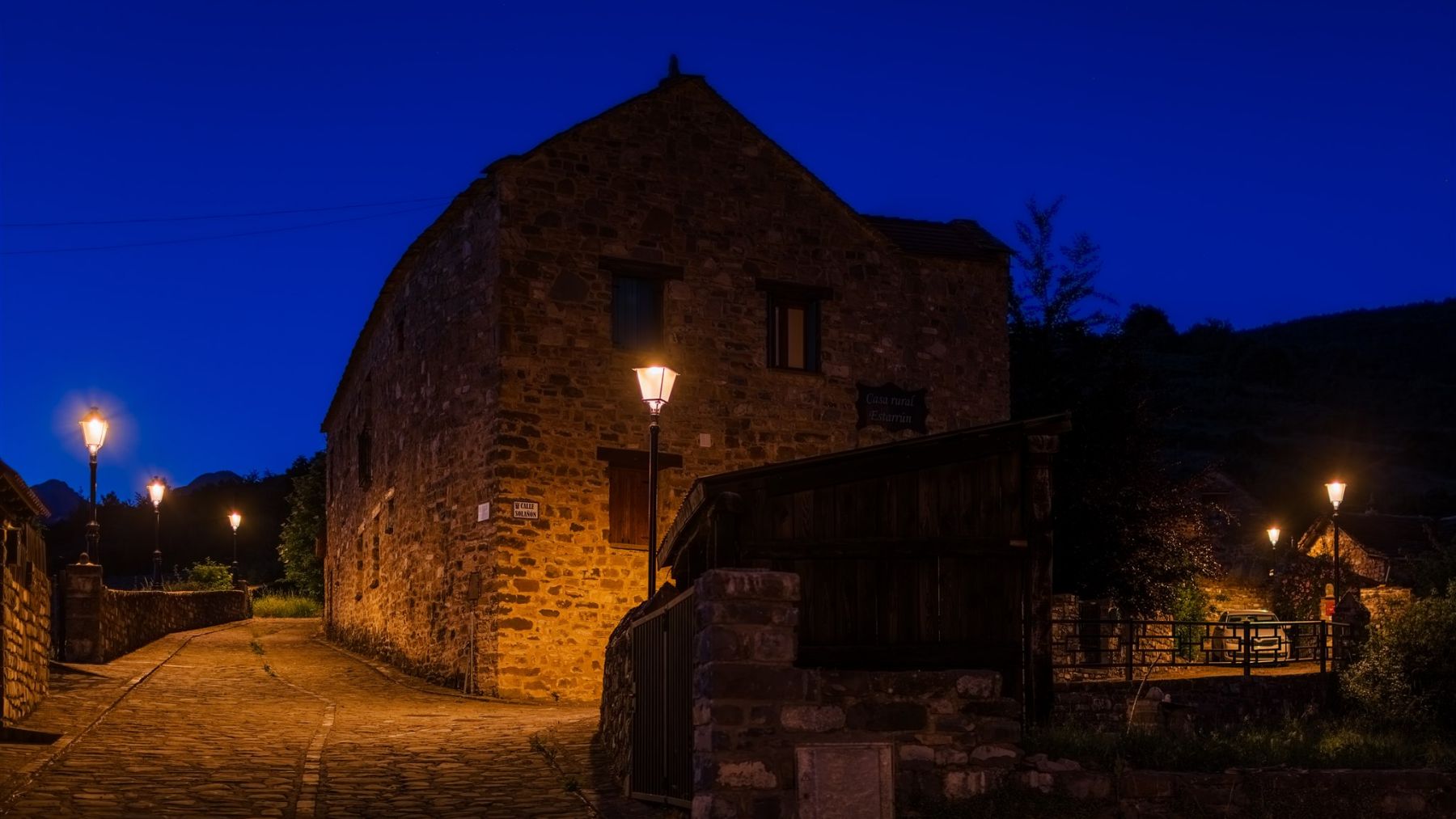 Vías de Aísa iluminadas con Villa XLA 2200 K y Difusor Confort®, realzando la arquitectura tradicional y el carácter acogedor del entorno. ATP ILUMINACIÓN