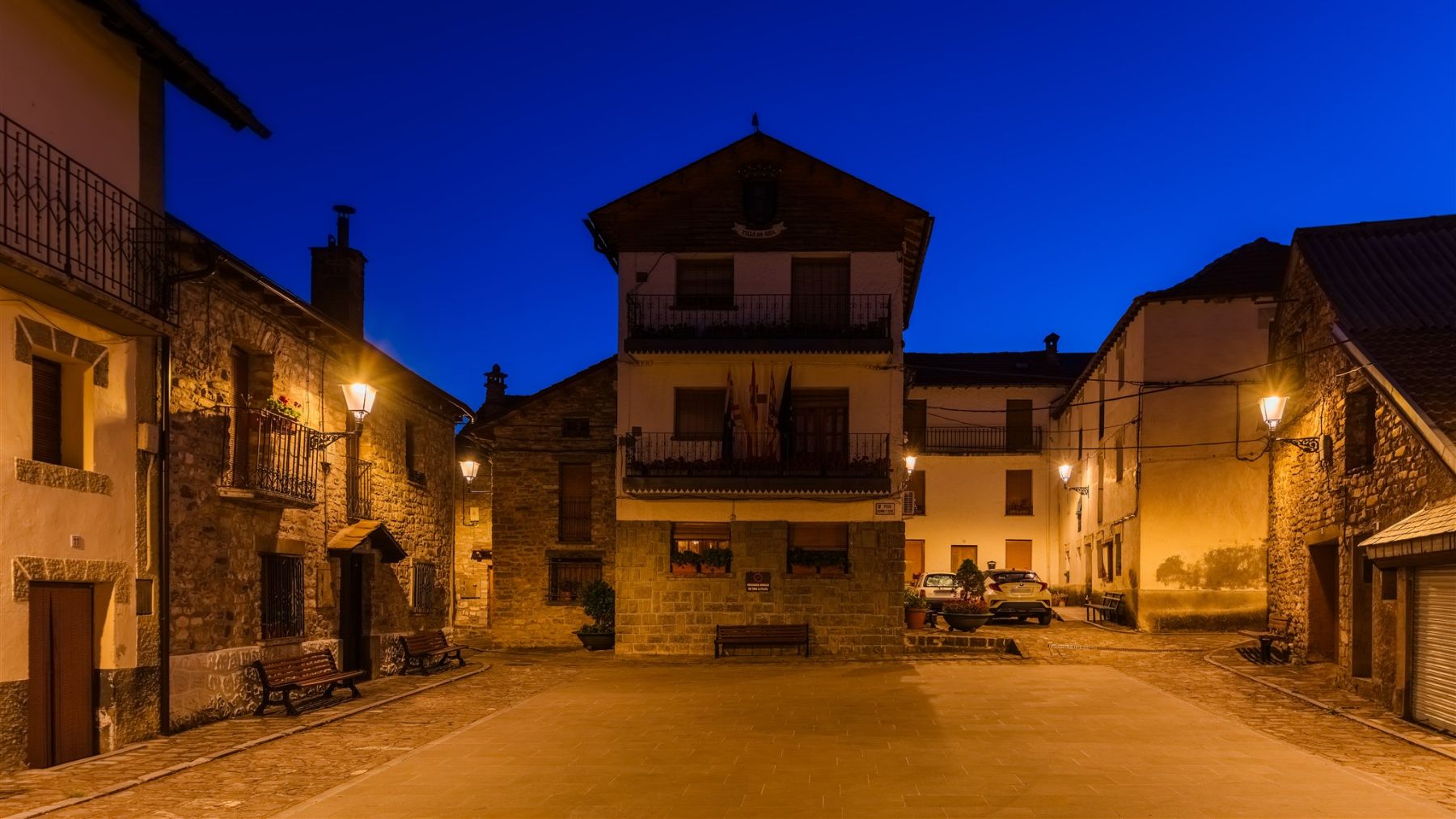 Vías de Aísa iluminadas con Villa XLA 2200 K y Difusor Confort®, destacando la estética pirenaica y el ambiente cálido del núcleo. ATP ILUMINACIÓN