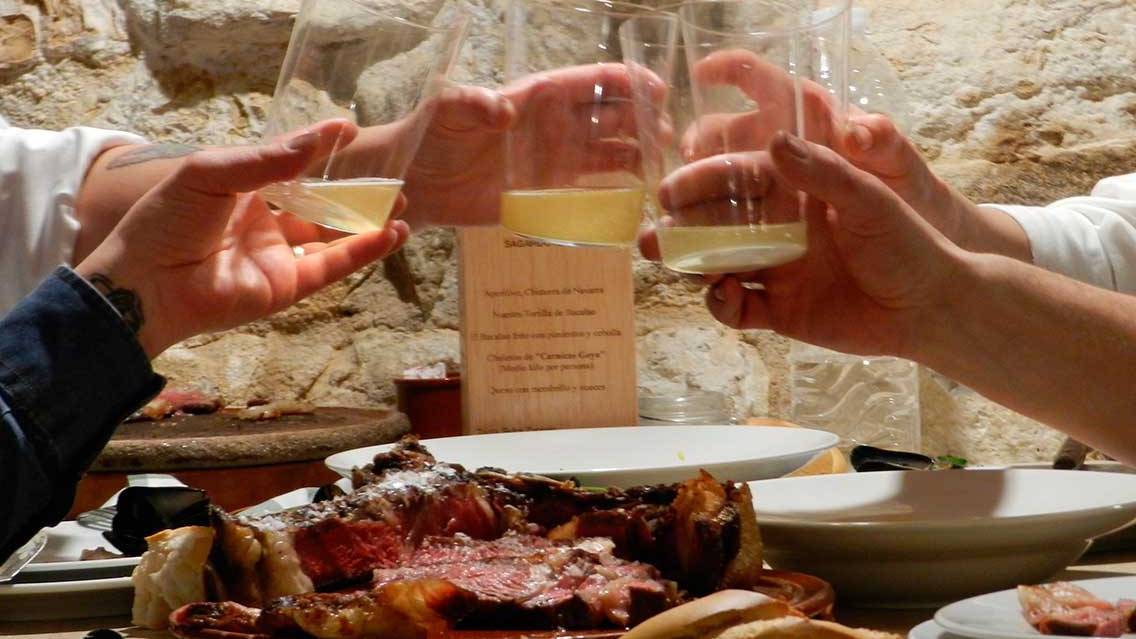 Un brindis con sidra y un plato de chuletón en Casa Armendáriz. CASA ARMENDÁRIZ