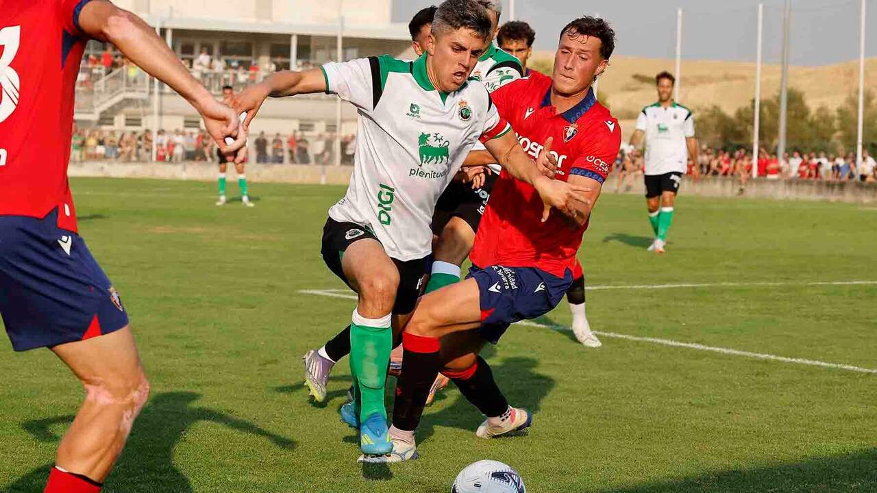 Iñigo Sainz Maza (c) del Racing y Jorge Herrando (d), de Osasuna, durante el partido amistoso de pretemporada que Osasuna y Racing disputan este viernes en la localidad navarra de Mendigorría. EFE/ Villar López
